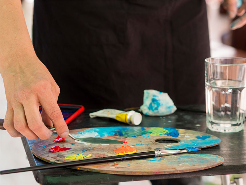 Corporate team building art workshop in Dubai with We Love Art - employees collaborating on paintings while building stronger workplace connections